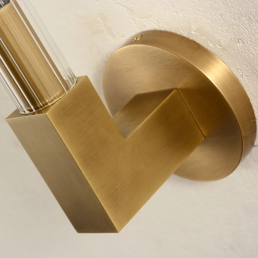 Close-up of the brushed brass mount and glass tube on a wall sconce